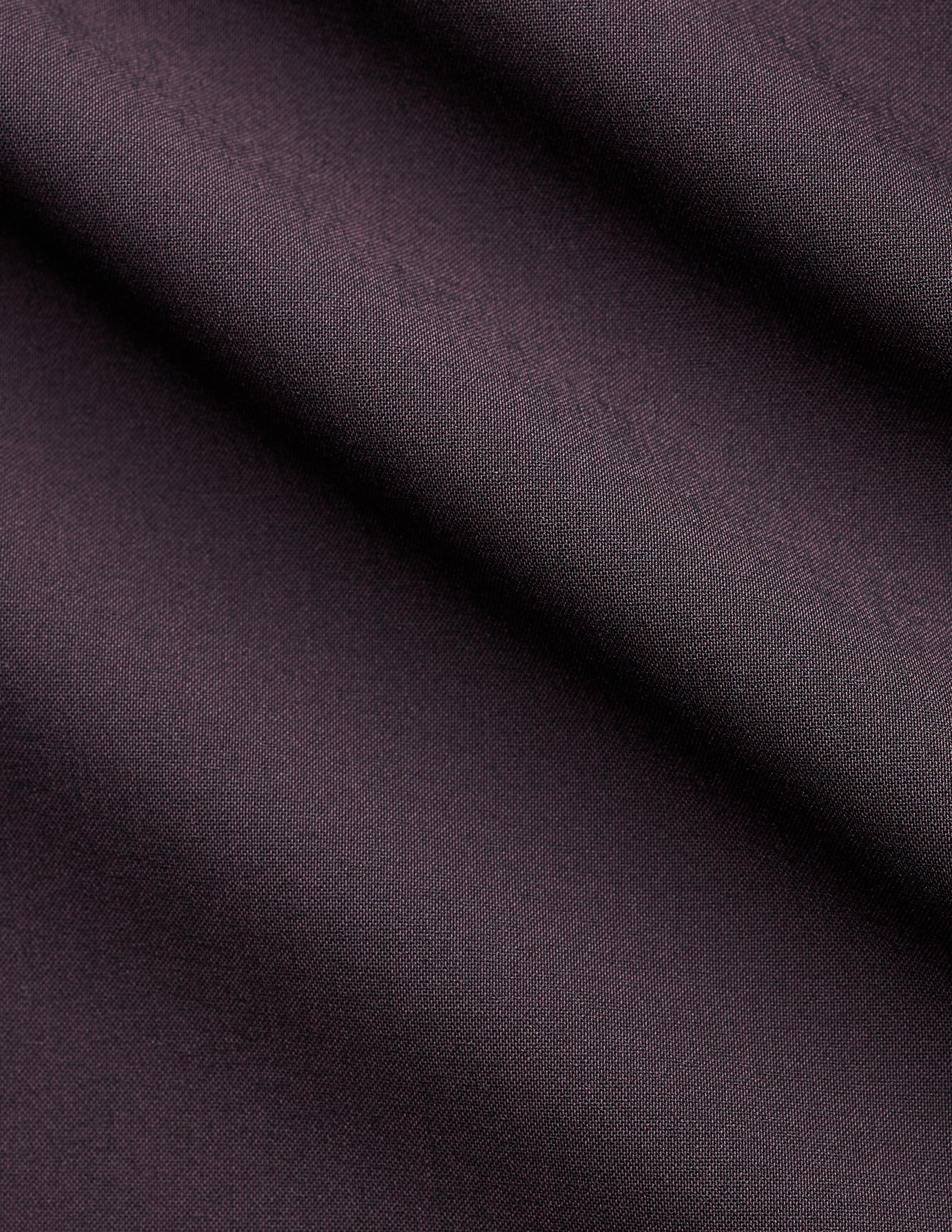 Nærbillede af det foldede, mørkviolette stof fra kollektionen »Women’s Avira Pants Wide Burgundy Berry«.