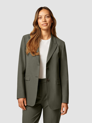 En kvinde iført en hvid T-shirt og en Essential Blazer i farven Dark Olive.