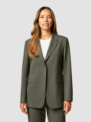 En kvinde iført en Essential Blazer i farven Dark Olive over en hvid T-shirt.