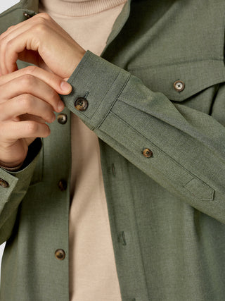 Et nærbillede af en person, der retter på den knaplukkede manchet på en Essential Overshirt i farven Nightfall Green Melange.