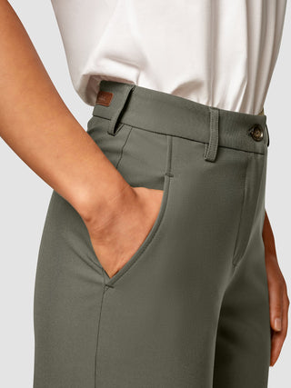 En person, der har Essential Pants Straight Dark Olive på og har en hånd i sidelommen.