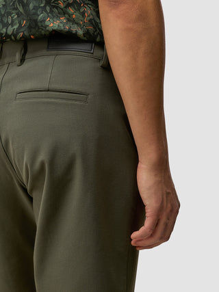 Et nærbillede af en person, der bærer GEN2™-shorts i farven »Muted Green« med en tydelig twill-struktur og en sort skjorte.