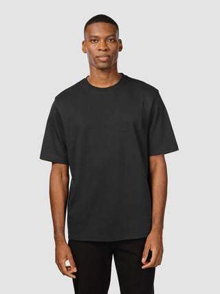 En mand iført en sort Heavy Box Fit-T-shirt.
