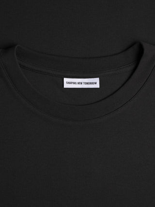 Heavy Box Fit T-shirt i sort med et »Shaping New Tomorrow«-mærke i nakken.