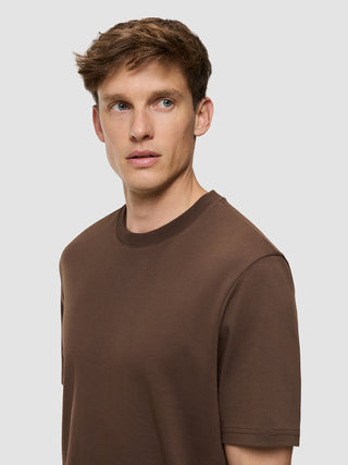 En mand iført en Heavy Box Fit-T-shirt i farven Saddle Brown.