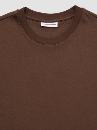 Heavy Box Fit T-shirt i sadelbrun med et »Shaping New Tomorrow«-mærke indeni rundhalsudskæringen.