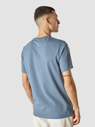 En mand set bagfra iført en Supima-T-shirt i farven Blue Mirage.
