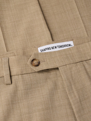 Nærbillede af Tech Wool Suit Sand-bukser med et Shaping New Tomorrow-mærke i linningen.