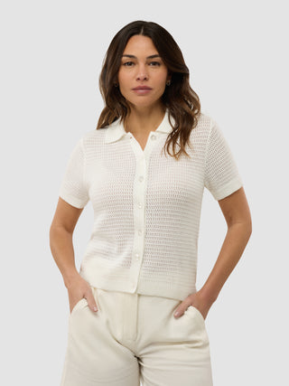 En kvinde iført en struktureret polo i farven Off White fra damekollektionen.