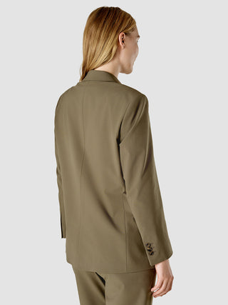 En kvinde set bagfra iført en Essential Suit Straight Dark Olive-blazer og matchende bukser.