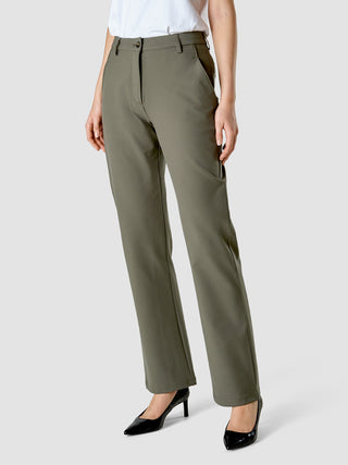 En person iført Essential Suit Straight Dark Olive-bukser, en hvid T-shirt og sorte højhælede sko med spids tå.