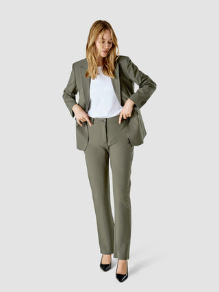 En kvinde iført et Essential Suit Straight i farven Dark Olive over en hvid T-shirt.