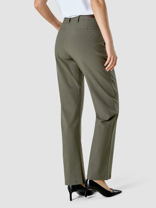 En person set bagfra, iført det olivengrønne Essential Suit Straight Dark Olive-sæt og sorte højhælede sko.