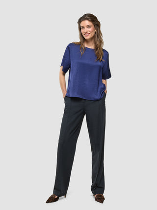 Amara Blouse i Navy, helfigur med model iført marineblå bluse og sorte bukser.