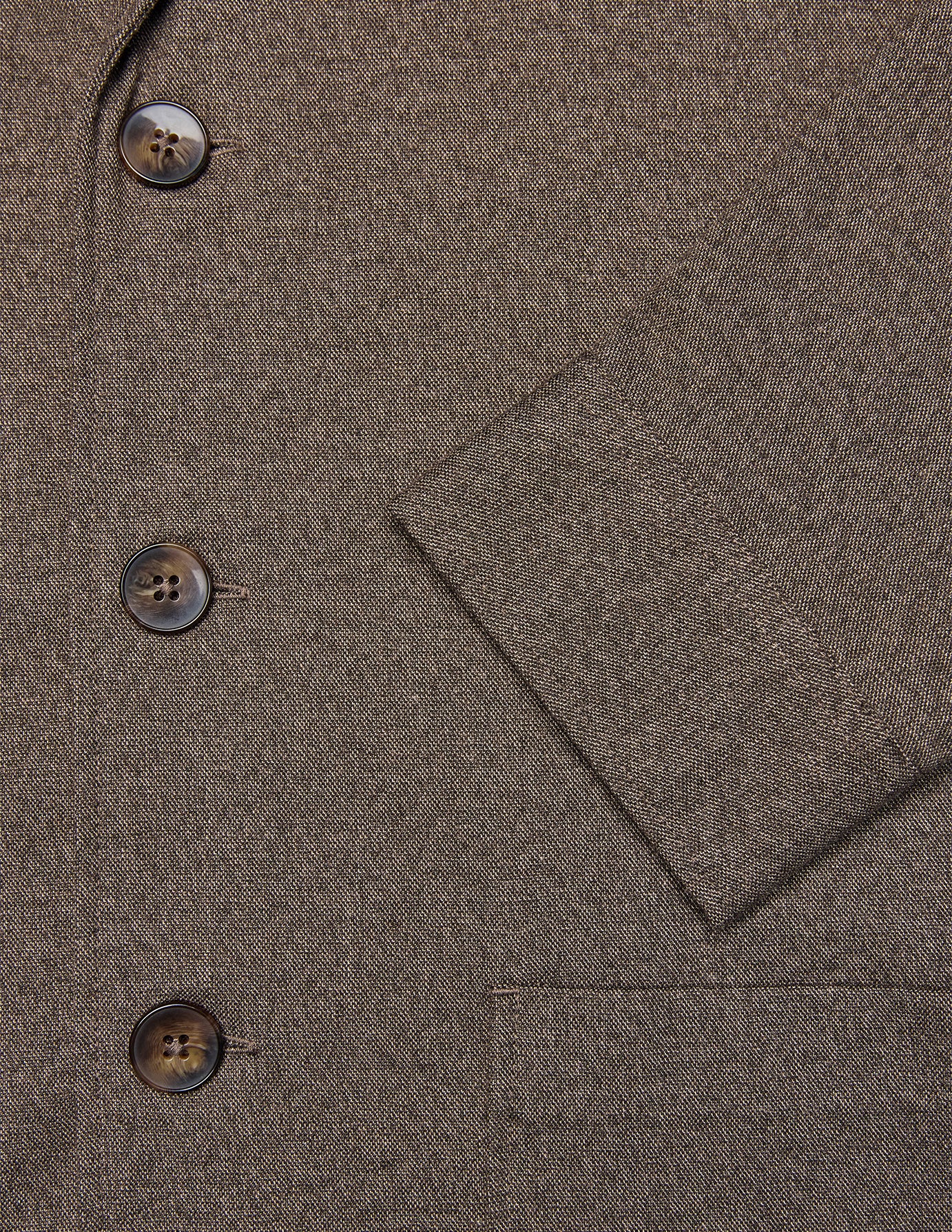 Nærbillede af den mørkebegige Atelier Overshirt-blazer med tre brune knapper og en lomme.