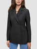 En person har en sort Avira-blazer til kvinder i dobbeltradet stil med spidse revers på over et par blå jeans.