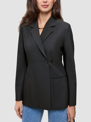 En person har en sort Avira-blazer til kvinder i dobbeltradet stil med spidse revers på over et par blå jeans.