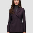 En kvinde iført en dobbeltradet Women’s Avira Blazer i farven Burgundy Berry over en grå rullekravebluse.