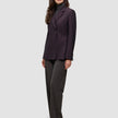 En kvinde iført en Avira-blazer i farven Burgundy Berry over en grå rullekravebluse og mørke bukser i dansk stil.