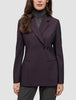 En person iført en Avira-blazer i farven Burgundy Berry til kvinder over en grå rullekravesweater, der afspejler klassisk dansk design.