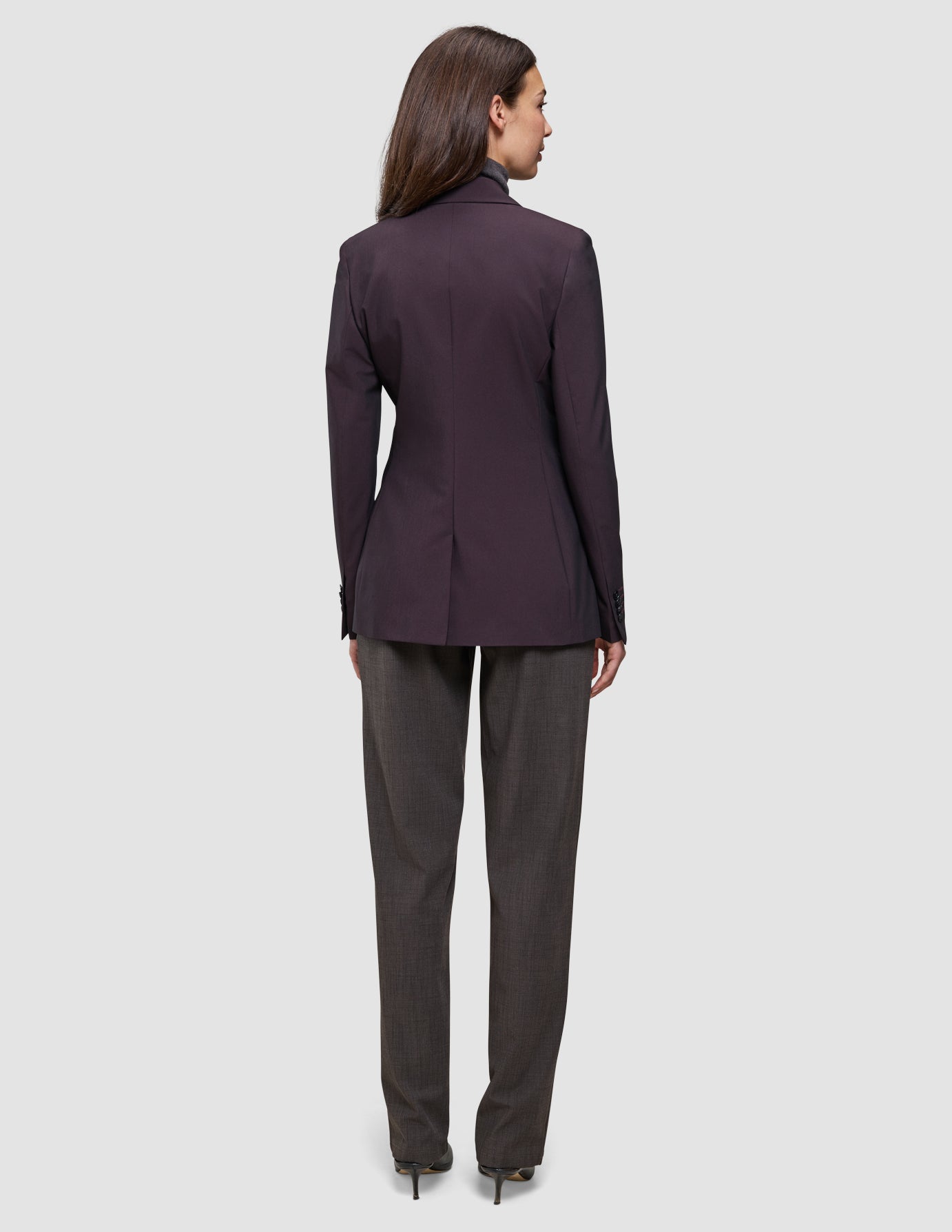 Bagfra-billede af en kvinde iført en mørk burgunderfarvet Women’s Avira Blazer Burgundy Berry og antracitgrå bukser.