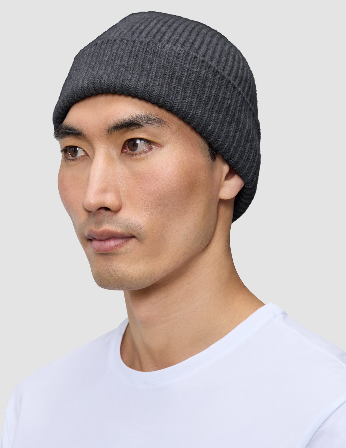 En person, der bærer en mørkegrå, ribbet hue med dansk design.