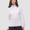 En kvinde iført en Women’s Chunky Soft Wool Knit Turtleneck Sugar Melange-trøje med høj hals i grovstrik.