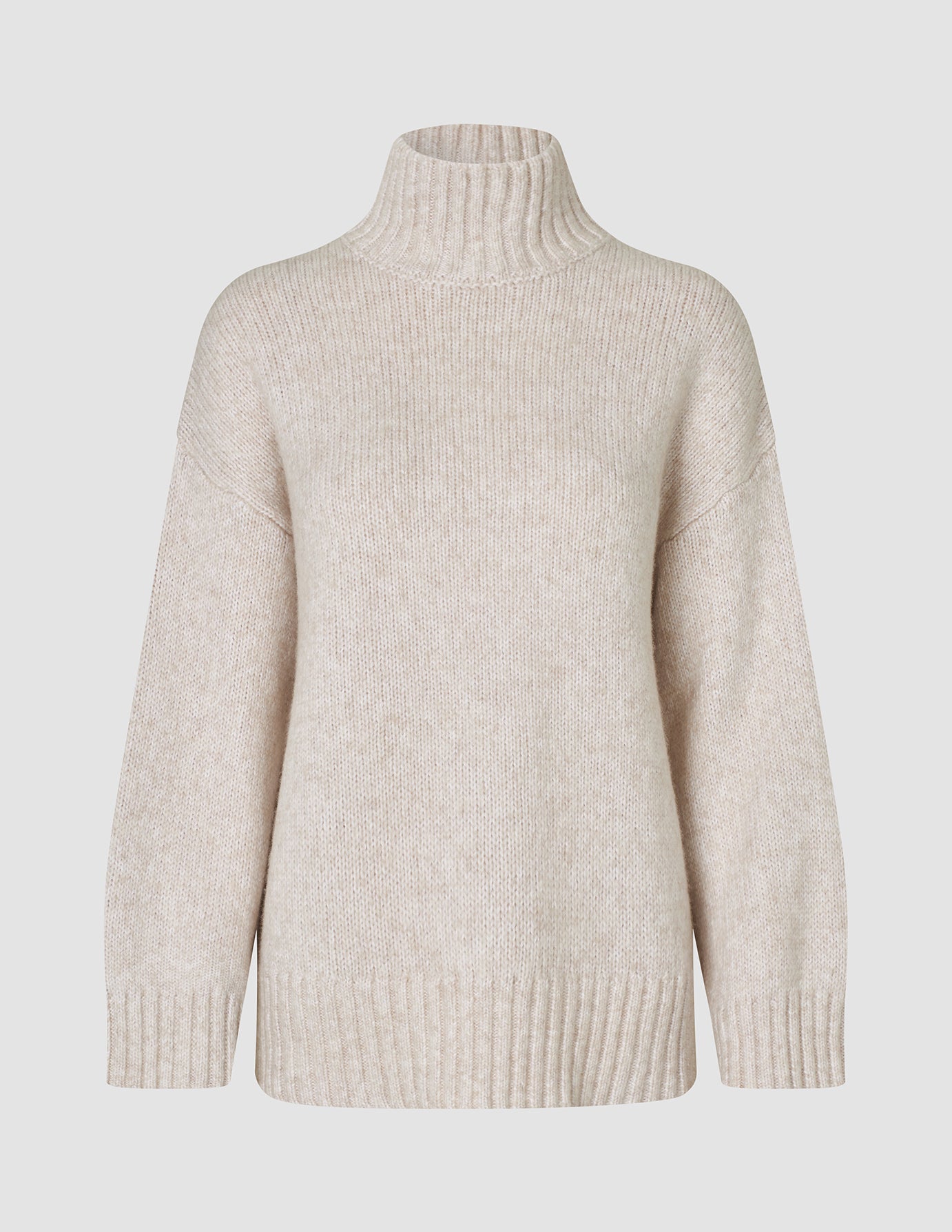 Damestrikket rullekravebluse i tyk, blød uld i farven Sugar Melange – et beige, groft ribstrikket design med rullekrave.