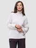 En kvinde har en Women’s Chunky Soft Wool Knit Turtleneck Sugar Melange på, en oversized, off-white trøje i grovstrikket design.