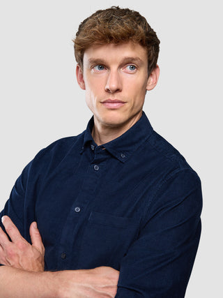 Corduroy Shirt i Dark Navy, helfigur af mand med krydsede arme.