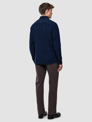Corduroy Shirt i Dark Navy, mand set bagfra i helfigur med mørkebrun bukser og sorte sko.