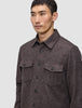 En person, der bærer en brun, langærmet Double Layer Wool Overshirt med knapper og to brystlommer.