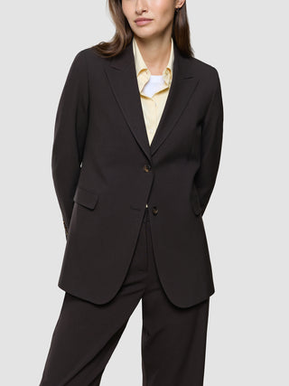En person har en Women Ease Blazer i farven Mocha Melange på over en lysegul skjorte med krave og en hvid T-shirt.