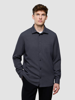 En mand har en antracitgrå »Effortless Shirt Dark Grey« på over en hvid T-shirt.