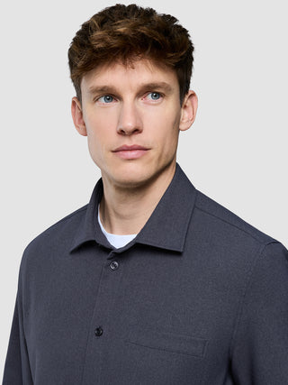 En mand, der har en mørkegrå Effortless-skjorte på over en hvid T-shirt med rund hals.