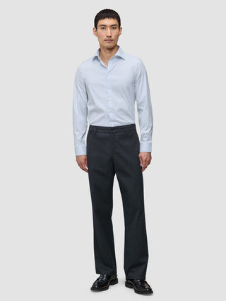 En mand iført en Elevated Shirt Regular Classic Blue Striped, mørke bukser og sorte loafers.