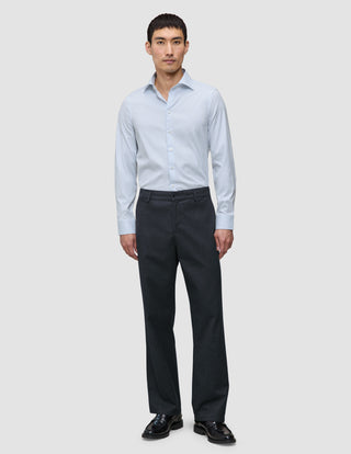 En mand iført en Elevated Shirt Regular Classic Blue Striped, mørke bukser og sorte loafers.