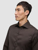 En mand iført en mørkebrun Elevated Shirt Regular-skjorte med knapper.