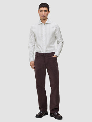 En mand iført en Elevated Shirt Regular i lysegrå striber og mørkebrune bukser.