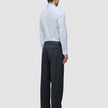 En mand set bagfra, iført en Elevated Shirt Slim Classic Blue Striped-skjorte og antracitgrå bukser.