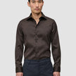En mand iført en Elevated Shirt Slim Dark Brown i slim fit, mørkebrun Pima-bomuld med button-down-krave.