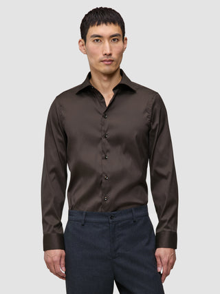 En mand iført en Elevated Shirt Slim Dark Brown i slim fit, mørkebrun Pima-bomuld med button-down-krave.