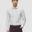En mand iført en Elevated Shirt Slim Light Grey Striped, der er fremstillet af lysegråt stof med tynde lodrette striber.