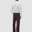 Bagfra-billede af en person iført en Elevated Shirt Slim i lysegrå striber og mørkebrune bukser.