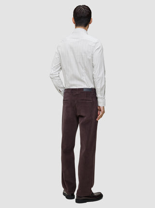 Bagfra-billede af en person iført en Elevated Shirt Slim i lysegrå striber og mørkebrune bukser.