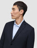 En mand iført en Motion Blazer Regular i farven Midnight Blue, som han har taget på over en lyseblå stribet skjorte.