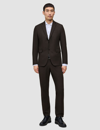 En mand iført en mørkebrun Motion Blazer Slim Cognac, en hvid skjorte og sorte herresko.