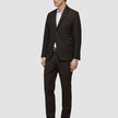 En mand iført en Motion Blazer Slim i farven Cognac, en hvid skjorte og sorte lædersko, der fremhæver det minimalistiske danske design.