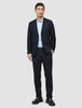 En mand iført en Motion Blazer Slim i farven Midnight Blue, en lyseblå skjorte og mørke læderloafers.