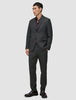 En mand iført en Motion Blazer Slim i farven Pepper Grey, en mørk skjorte med knapper og mørke loafers i et klassisk dansk design.